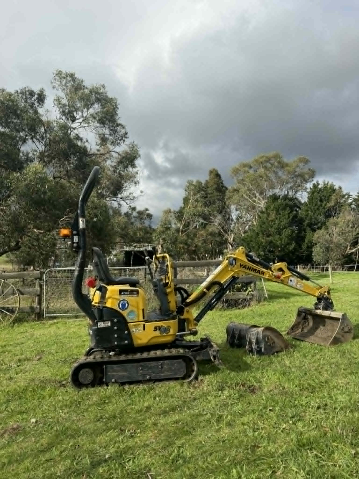 Yanmar SV08-1A mini excavator with two buckets in a paddock, ready for hire in South East Melbourne